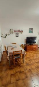 a dining room with a table and chairs and a television at Zorel House in Siena