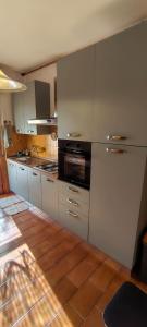 a kitchen with white cabinets and a refrigerator at Zorel House in Siena