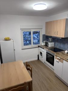 a kitchen with a table and a refrigerator and a microwave at Casa La Peña in Luarca