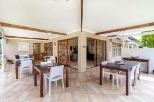 a dining room with wooden tables and white chairs at Comfort on Cabot in Edenvale