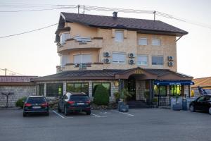 a building with cars parked in a parking lot at Motel Atos in Laktaši
