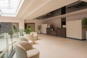 eine Bürolobby mit Stühlen und einem Oberlicht in der Unterkunft Santana Hotel & SPA in St Paul's Bay + 71 Fotos