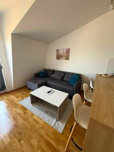a living room with a couch and a table at Modern Luxury Apartment with Private Garage in Stara Varoš
