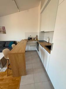 a kitchen with white cabinets and a wooden counter top at Modern Luxury Apartment with Private Garage in Stara Varoš