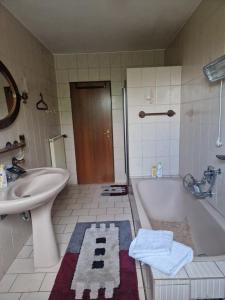 a bathroom with a tub and a sink and a bath tub at Schönes Doppelzimmer in Allmannshofen