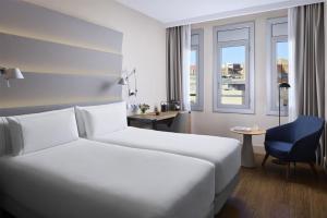 a hotel room with a bed and a desk at NH Sants Barcelona in Barcelona