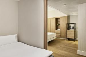 a bedroom with a bed and a mirror at NH Sants Barcelona in Barcelona
