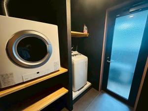 a small bathroom with a washing machine in a room at Casa Luce Sasebo Hotel in Sasebo