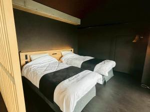 two beds in a room with twothirdsebin at Casa Luce Sasebo Hotel in Sasebo +2 photos