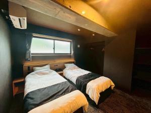 a room with two beds and a window at Casa Luce Sasebo Hotel in Sasebo