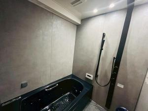 a bathroom with a bath tub with a shower at Casa Luce Sasebo Hotel in Sasebo
