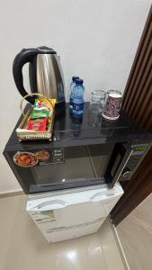 a black counter top with a tea kettle and food at Albazar Residence Salalah in Salalah