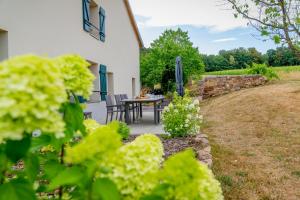 a patio with a table and chairs in a yard at Gîte L'instant Vosges in Aydoilles