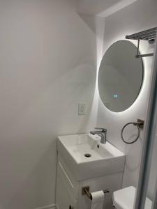 a white bathroom with a sink and a mirror at Oshawa Suite Open Kitchen Living Space in Oshawa