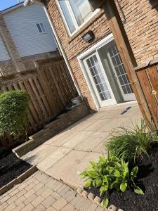 a house with a wooden fence and a patio at Oshawa Suite Open Kitchen Living Space in Oshawa