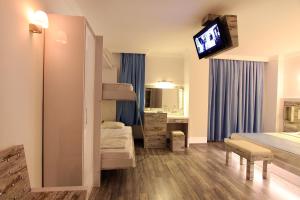 a bedroom with bunk beds and a tv on the wall at Nur Hotel in Kaş