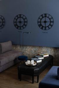 a living room with a couch and clocks on the wall at Impresamente Art Hotel in Sofia