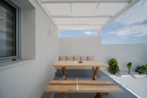 a wooden table in a room with a window at Caldera's Elements in Santorini