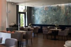 a restaurant with tables and chairs and a large painting on the wall at Impresamente Art Hotel in Sofia