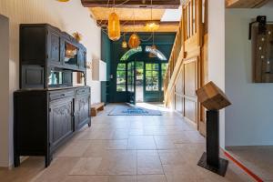a hallway with a kitchen with a stove and a doorway at Gîte L'instant Vosges in Aydoilles