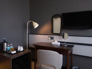 a room with a desk and a chair and a mirror at Merchant Hotel in George Town