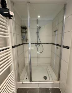 a shower with a glass door in a bathroom at Gemütliches Apartment in zentral mit Balkon in Bremen +1 photo