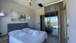 a bedroom with a bed with white sheets and pillows at Carmelia Villas in Agios Nikitas +51 photos