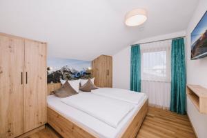 a bedroom with a large white bed and a window at Haus Martinus in Mayrhofen