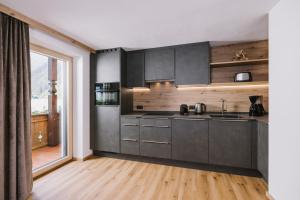 a kitchen with gray cabinets and a wooden floor at Haus Martinus in Mayrhofen