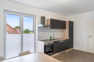a kitchen with black and white appliances and a table at Haus Seeluft - W4 in Butjadingen