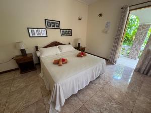a bedroom with a bed with two teddy bears on it at Villa Rafia in Baie Sainte Anne