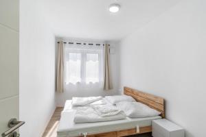 a bedroom with a bed with white sheets and a window at Haus Seeluft - W4 in Butjadingen