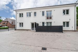 a large white house with a brick driveway at Haus Seeluft - W4 in Butjadingen