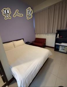 a bedroom with a white bed with writing on the wall at 浮雲澗民宿 in Hu-hsia +9 photos