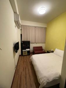 a hotel room with a bed and a chair at 浮雲澗民宿 in Hu-hsia
