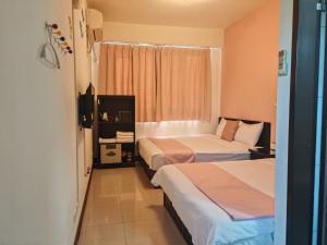 a hotel room with two beds and a window at 浮雲澗民宿 in Hu-hsia