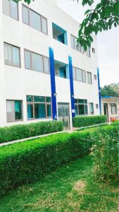 a large white building with blue columns at 浮雲澗民宿 in Hu-hsia