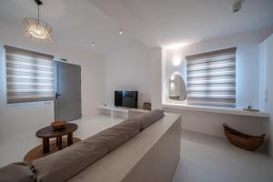 a living room with a couch and a television at Caldera's Elements in Santorini