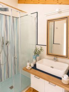 a bathroom with a sink and a shower at The Queen Oak - nature relais in Santa Marina