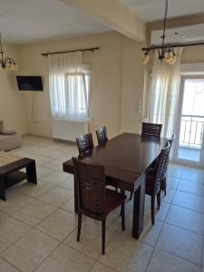 a dining room with a wooden table and chairs at Villa Aggelos in Skala Sotiros