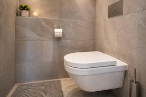 a bathroom with a white toilet in a room at Evergreen Tale Apartman F2 in Tale