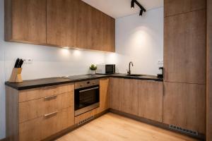 a kitchen with wooden cabinets and a sink at Evergreen Tale Apartman F2 in Tale