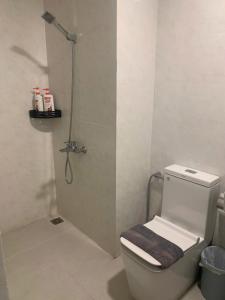 a bathroom with a shower with a toilet and a glass door at NAYO Cam Ranh - Beachfront Residence in Cam Ranh International Airport