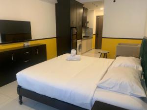 a bedroom with a large white bed with a flat screen tv at NAYO Cam Ranh - Beachfront Residence in Cam Ranh International Airport