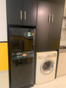 a kitchen with a washing machine and a microwave at NAYO Cam Ranh - Beachfront Residence in Cam Ranh International Airport