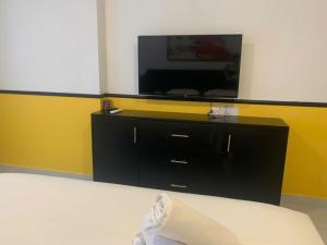 a room with a tv and a black dresser at NAYO Cam Ranh - Beachfront Residence in Cam Ranh International Airport