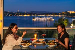 two women sitting at a table eating food at Panna Vilas - A Lake Facing Boutique Hotel in Udaipur