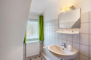 a bathroom with a sink and a mirror at Ferienhaus Adelheid in Bad Grund +34 photos
