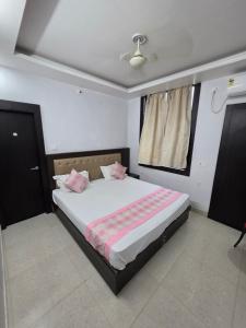 a bedroom with a bed with pink pillows on it at Karma Bodhgaya in Bodh Gaya