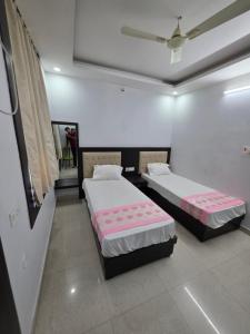 a room with two beds in a room with a ceiling at Karma Bodhgaya in Bodh Gaya
